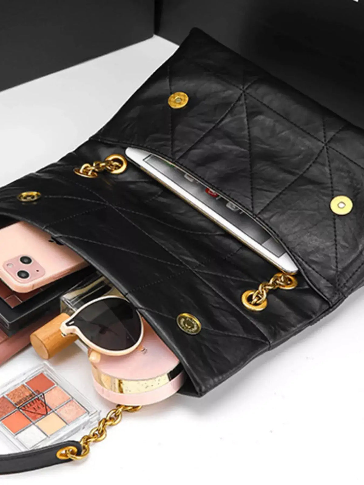 Inside view of a black geometric quilted PU leather shoulder bag from Evie's Dreamland with gold chain straps.