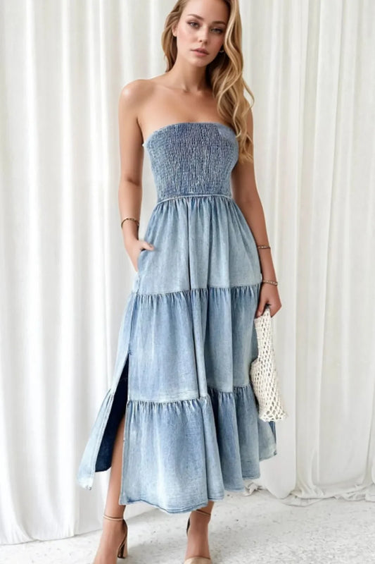 Woman modeling a strapless blue denim midi dress with tiered skirt and pockets
