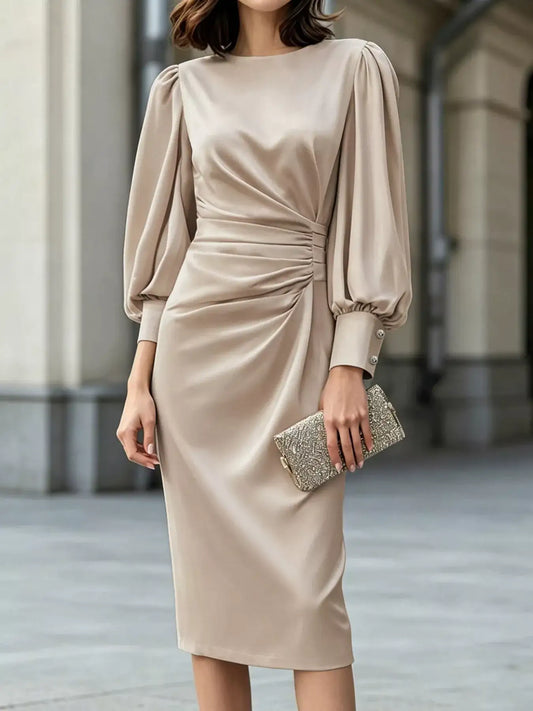 Champagne satin ruched midi dress by Evie's Dreamland with long puff sleeves and a gold clutch.