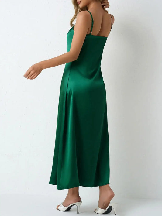 Back view of a woman wearing an emerald green satin slip maxi dress by Evie's Dreamland.