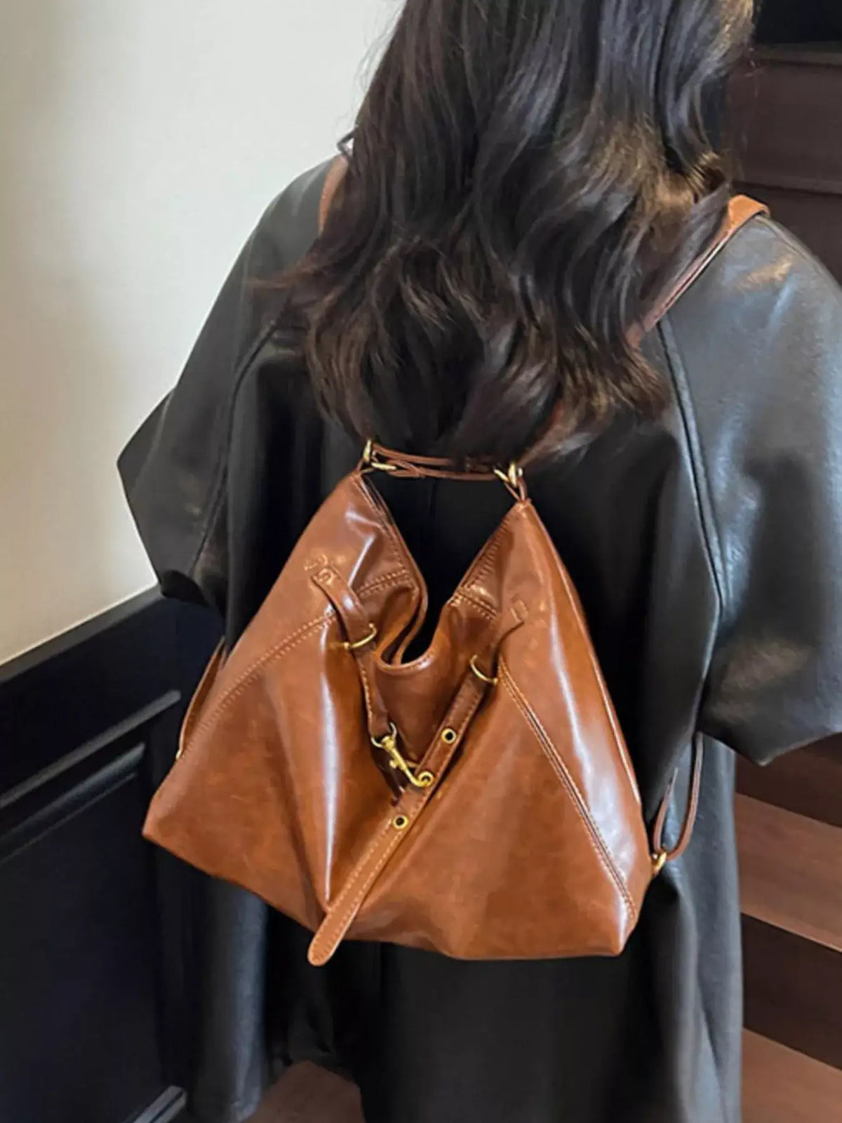 Brown vintage style PU leather crossbody bag worn over a black leather jacket by Evie's Dreamland.