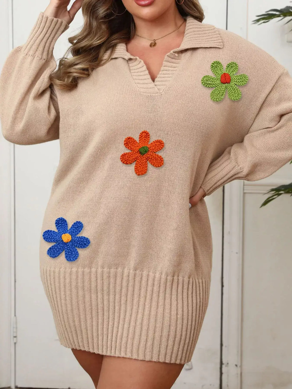 Beige plus size ribbed sweater dress by Evie's Dreamland with colorful floral appliqué and V-neckline.