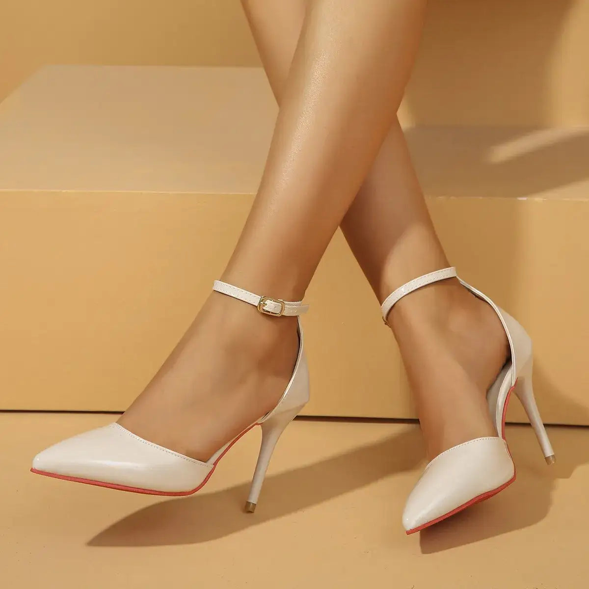 White pointed toe stiletto pumps with ankle straps and red soles from Evie's Dreamland.