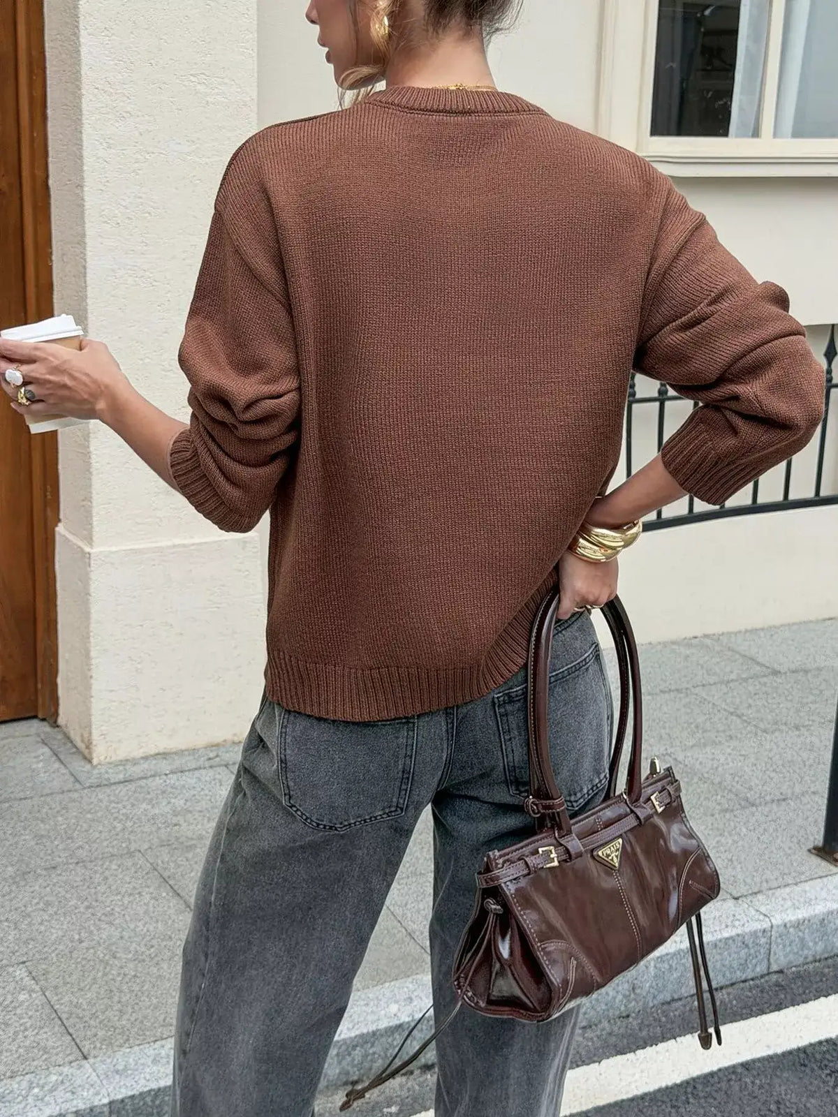 Woman wearing a brown crew neck ribbed hem sweater by Evie's Dreamland paired with grey jeans.