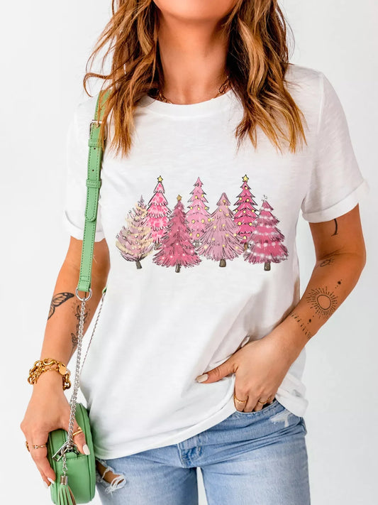 Woman wearing white t-shirt with pink Christmas tree graphic, light blue ripped jeans, green handbag