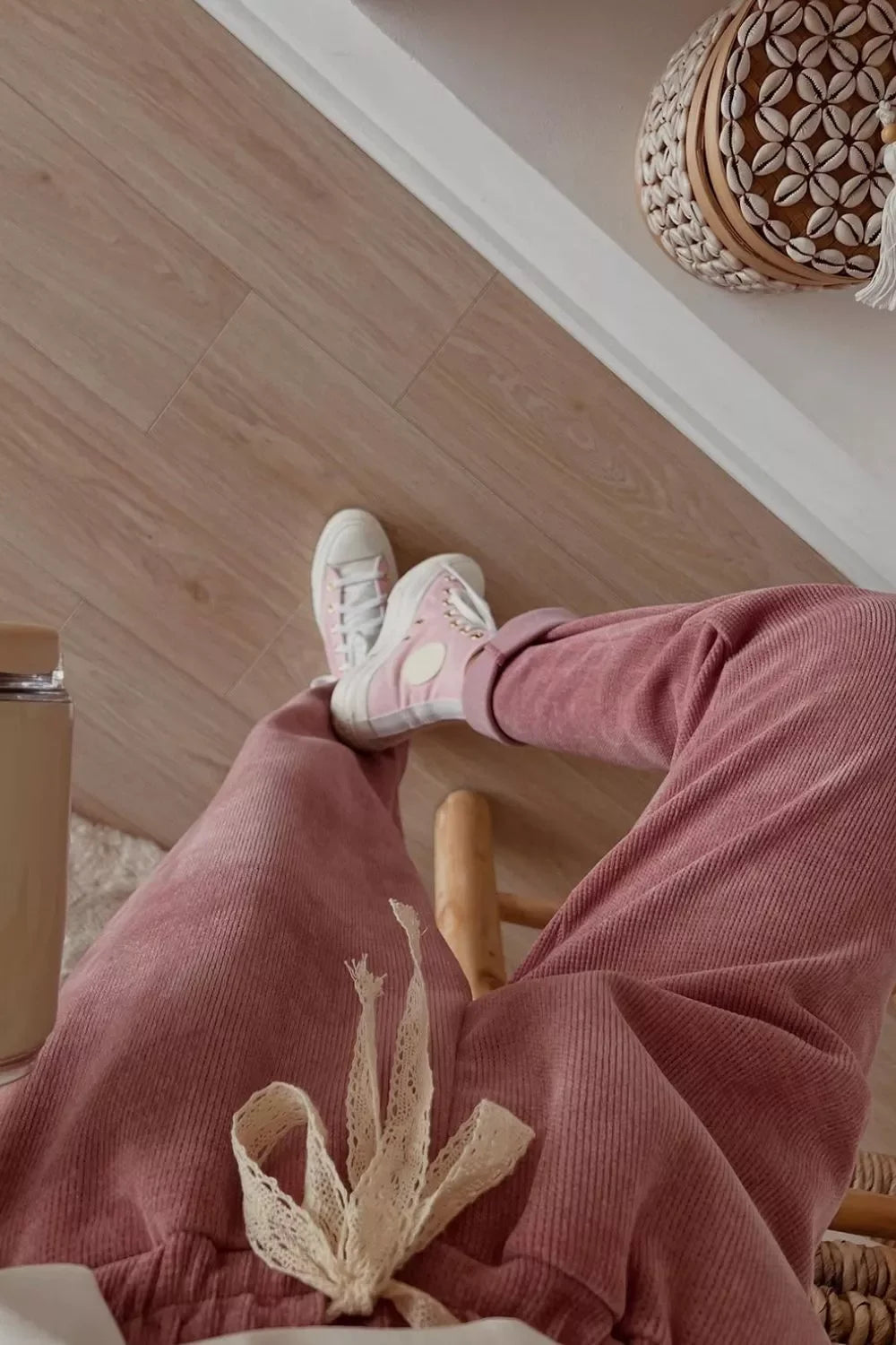 Pink corduroy joggers with lace tie, paired with pink high-top sneakers on wood floor