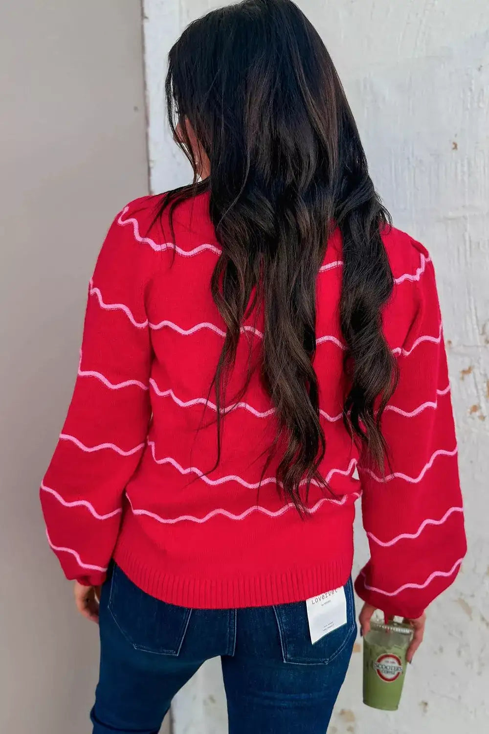 Back view of a red Evie's Dreamland long sleeve pullover sweater with white wavy stripes and puff sleeves.