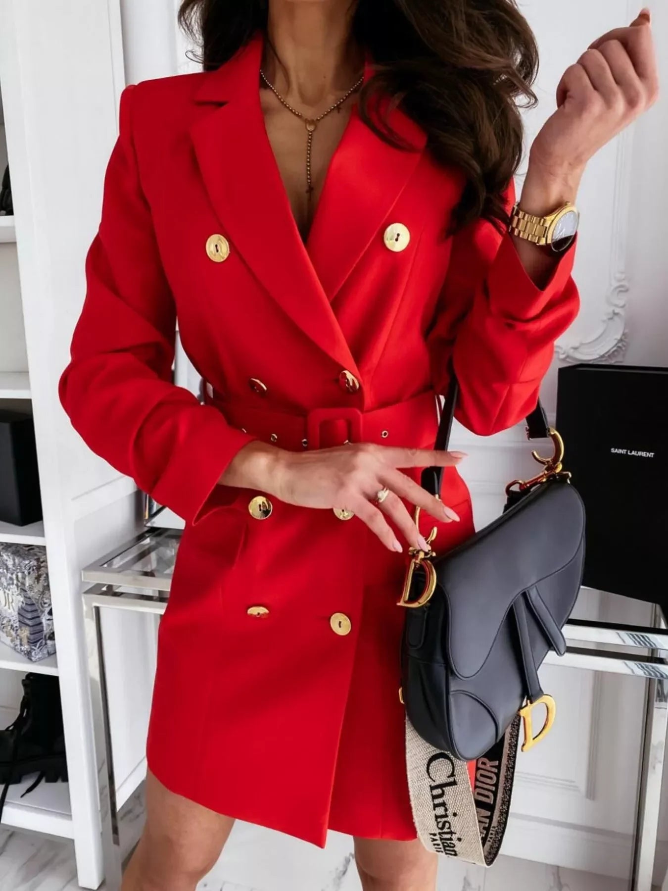Woman wearing red double-breasted blazer dress with gold buttons, holding black Christian Dior saddle bag