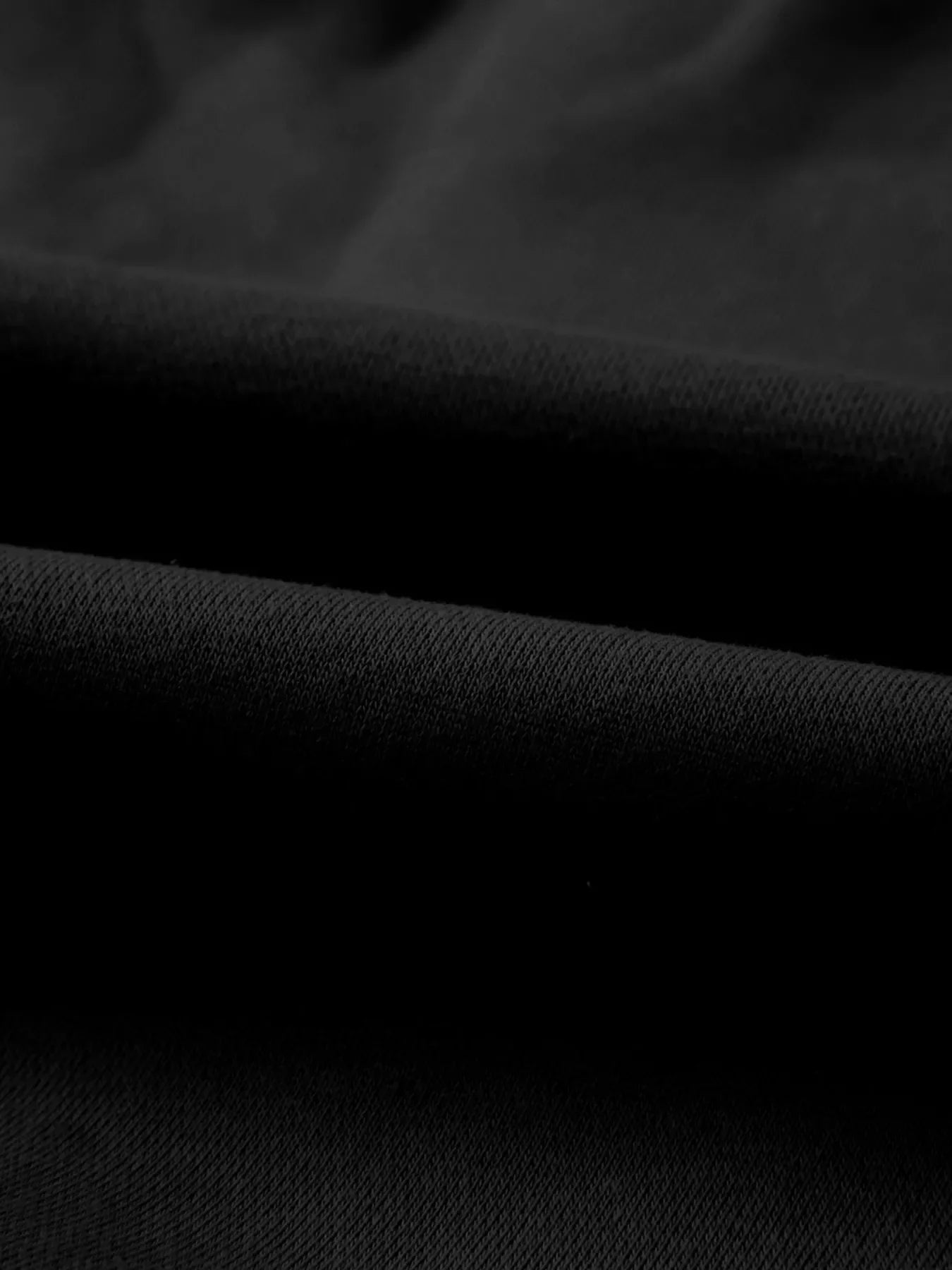Close-up of black folded fabric showing texture and fine knit pattern