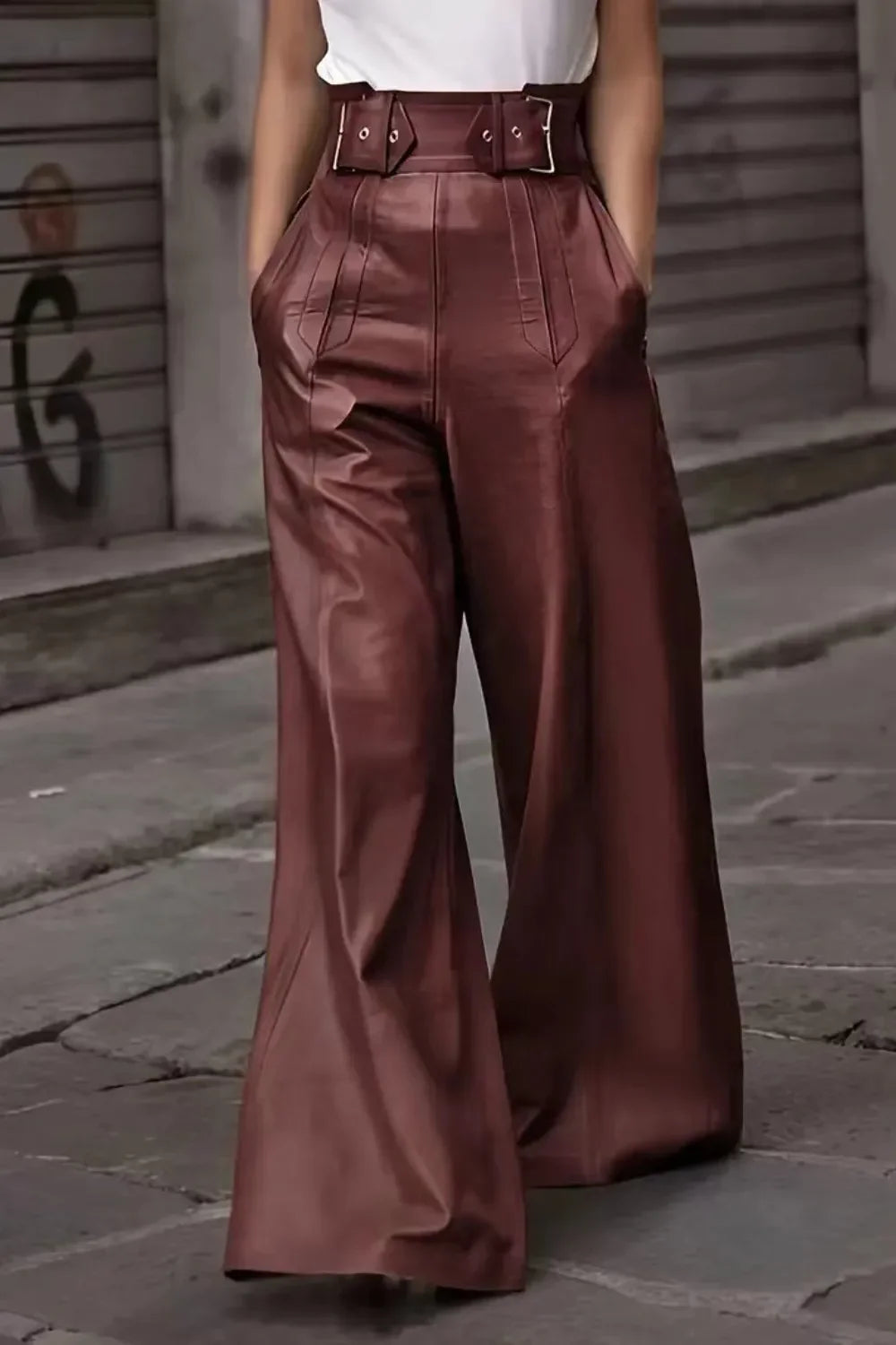 Close-up of wide-leg brown leather pants with high waist belt worn by model on street