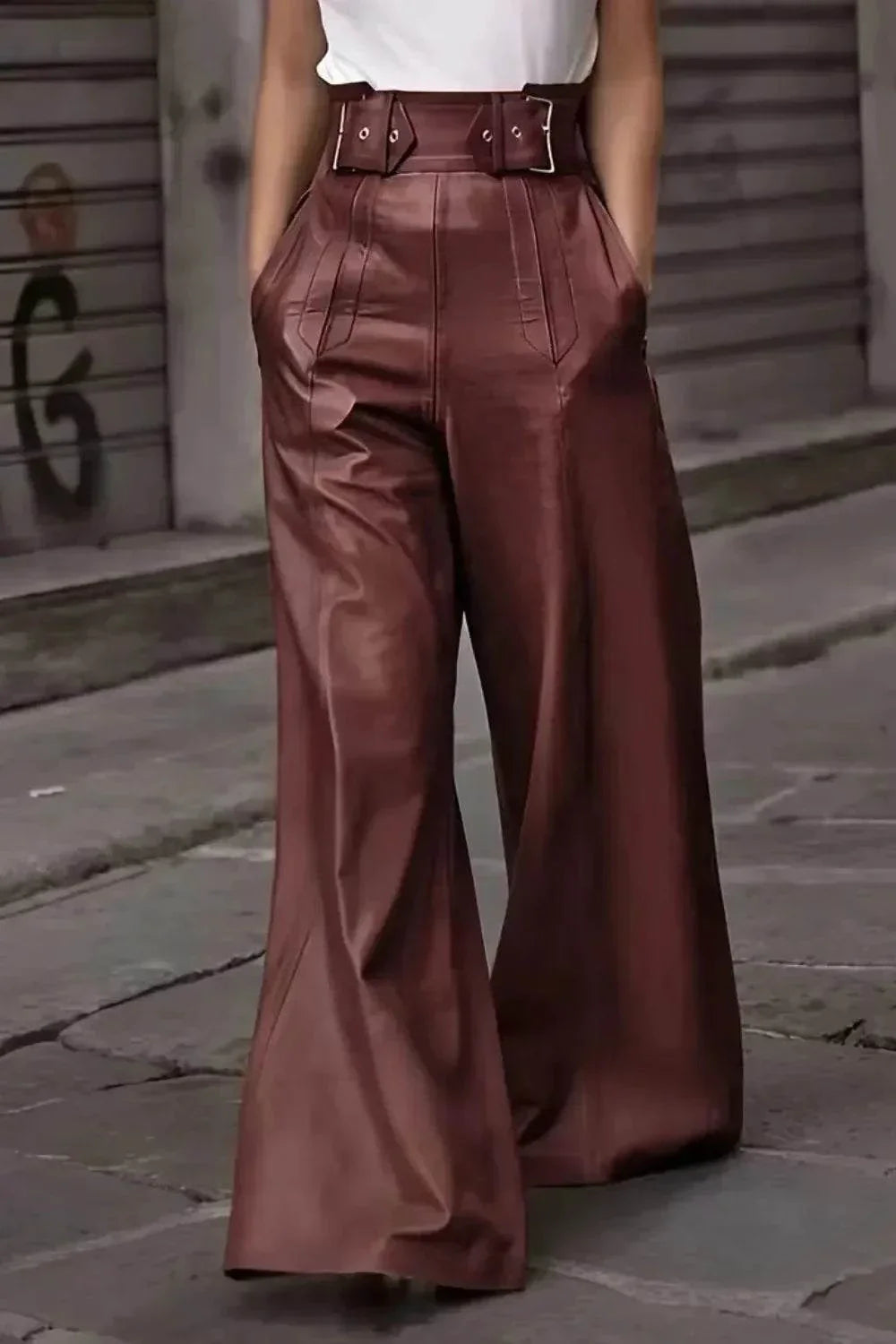 Close-up of wide-leg brown leather pants with high waist belt worn by model on street
