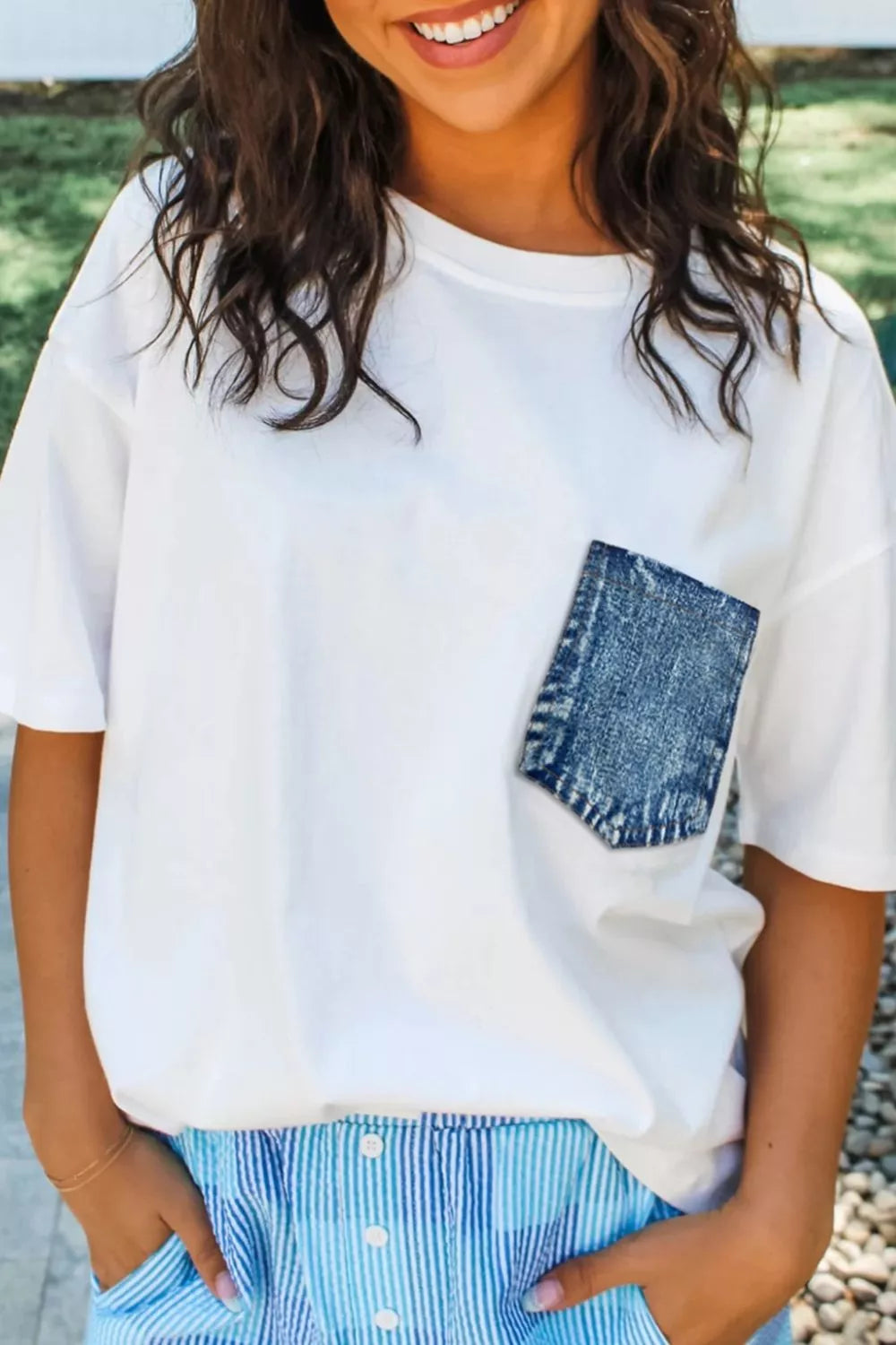 White t-shirt with denim pocket, styled with striped shorts for casual everyday wear