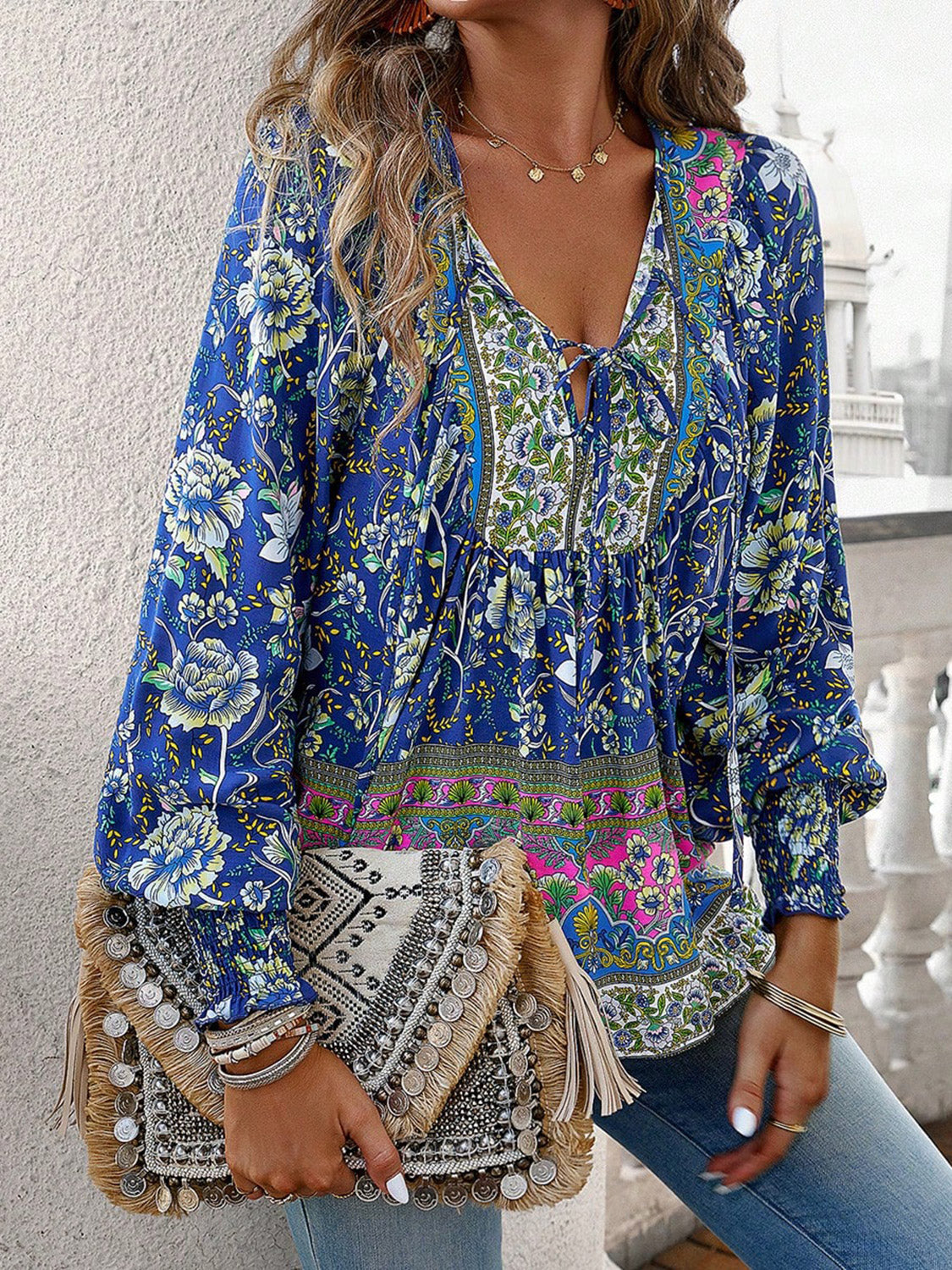 Boho floral blouse with long sleeves, V-neck tie, and fringe handbag for stylish everyday wear