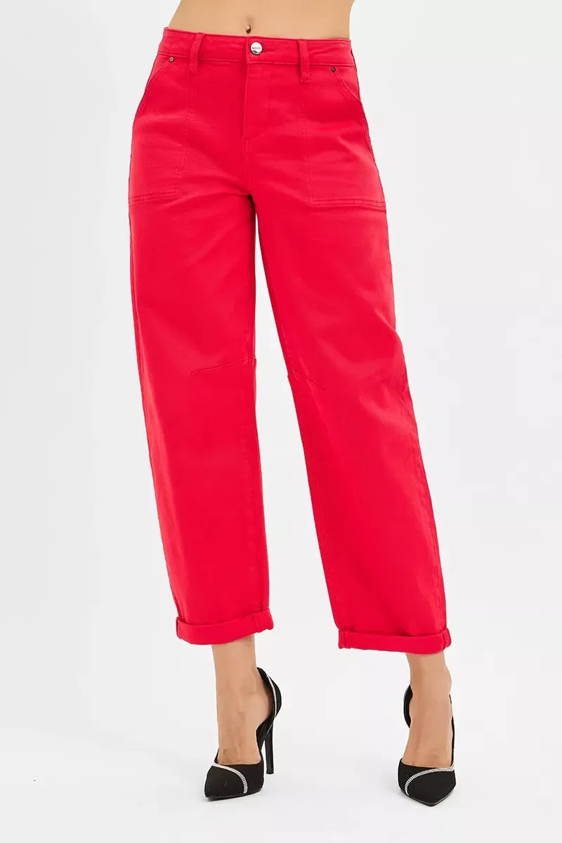 Woman wearing bright red high-waisted wide-leg pants with rolled cuffs and black high heels