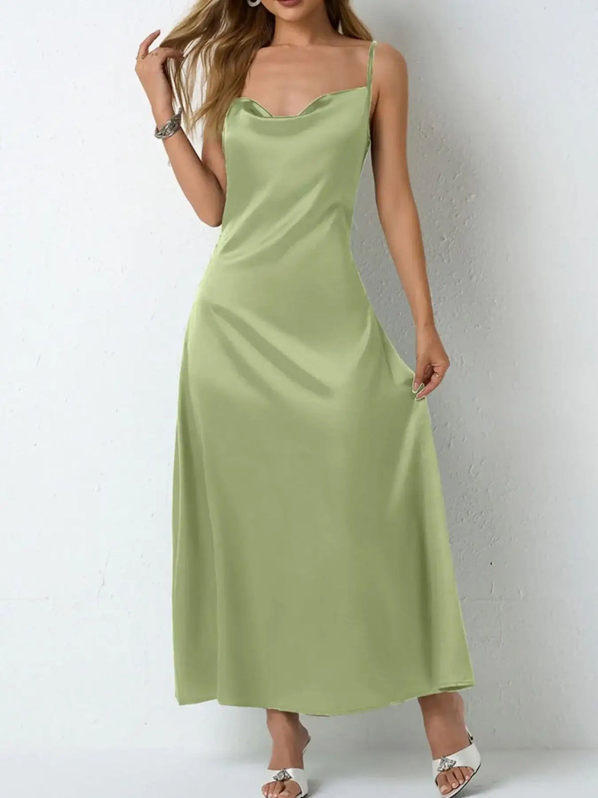 Woman wearing a sage green satin cowl neck slip maxi dress by Evie's Dreamland.