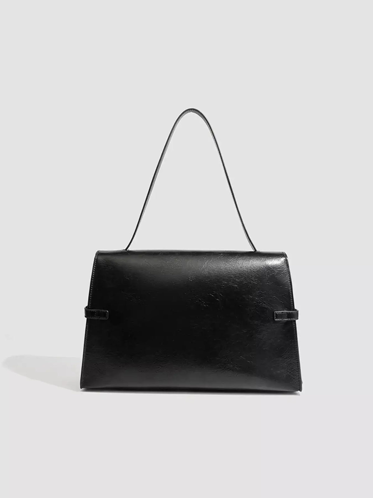 Evie's Dreamland black medium PU leather shoulder bag with a buckle closure and thin strap.
