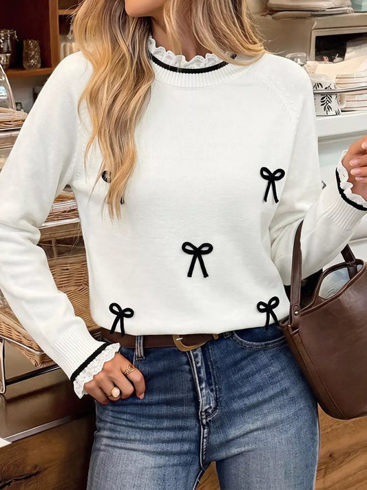 Evie's Dreamland white bow-embellished sweater with lace trim neckline and cuffs paired with blue jeans.