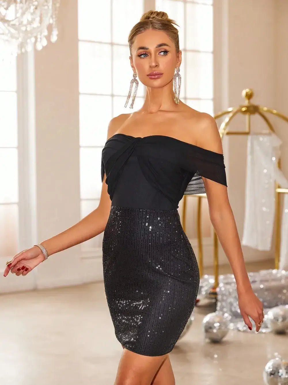 Woman wearing an Evie's Dreamland off-shoulder black mini dress with a sequined skirt for a party.