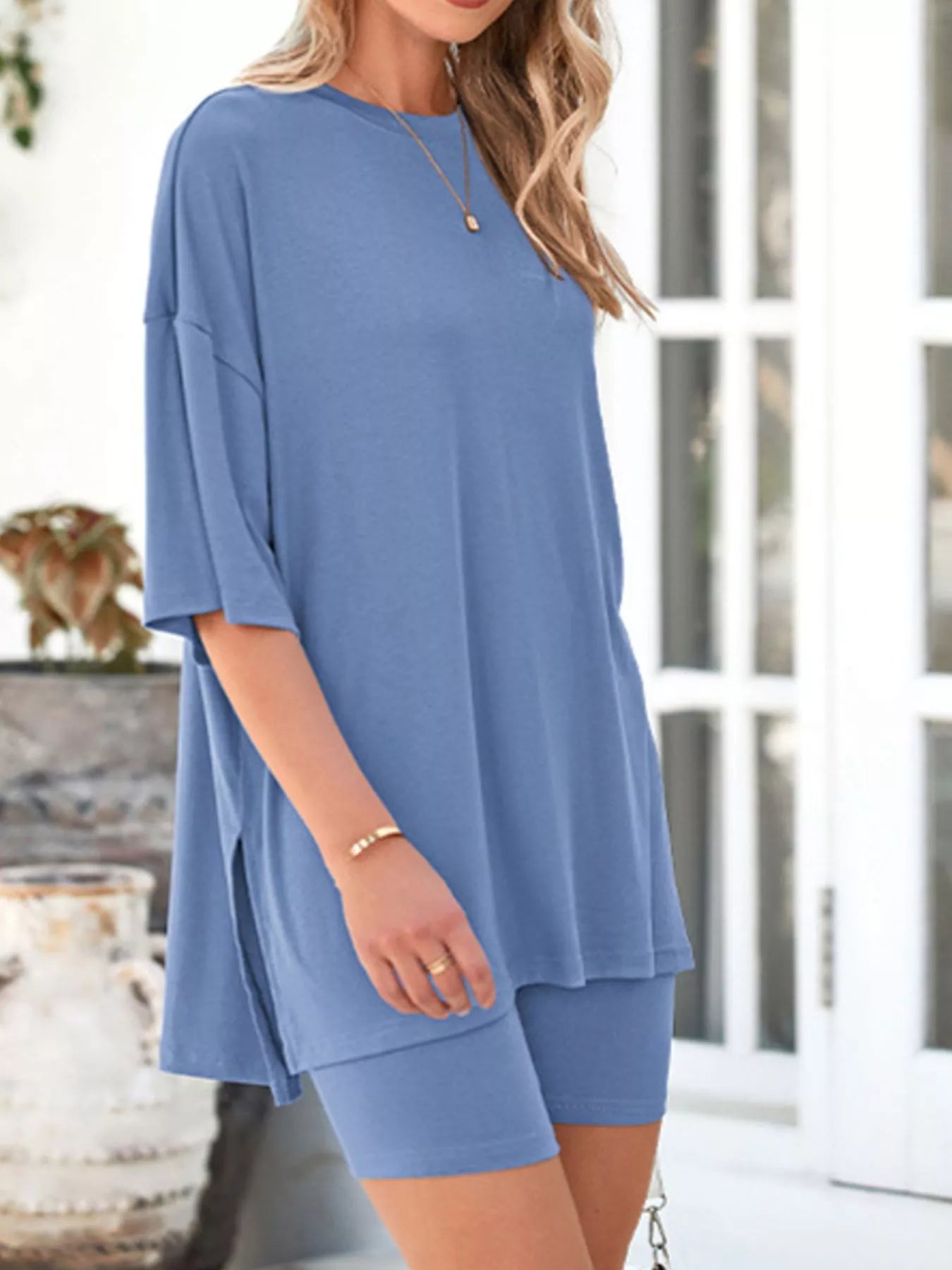Woman wearing a loose blue lounge set with oversized top and matching biker shorts
