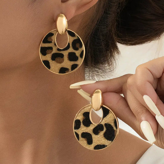 Evie's Dreamland 18K gold-plated leopard print circle dangle earrings worn on a woman.