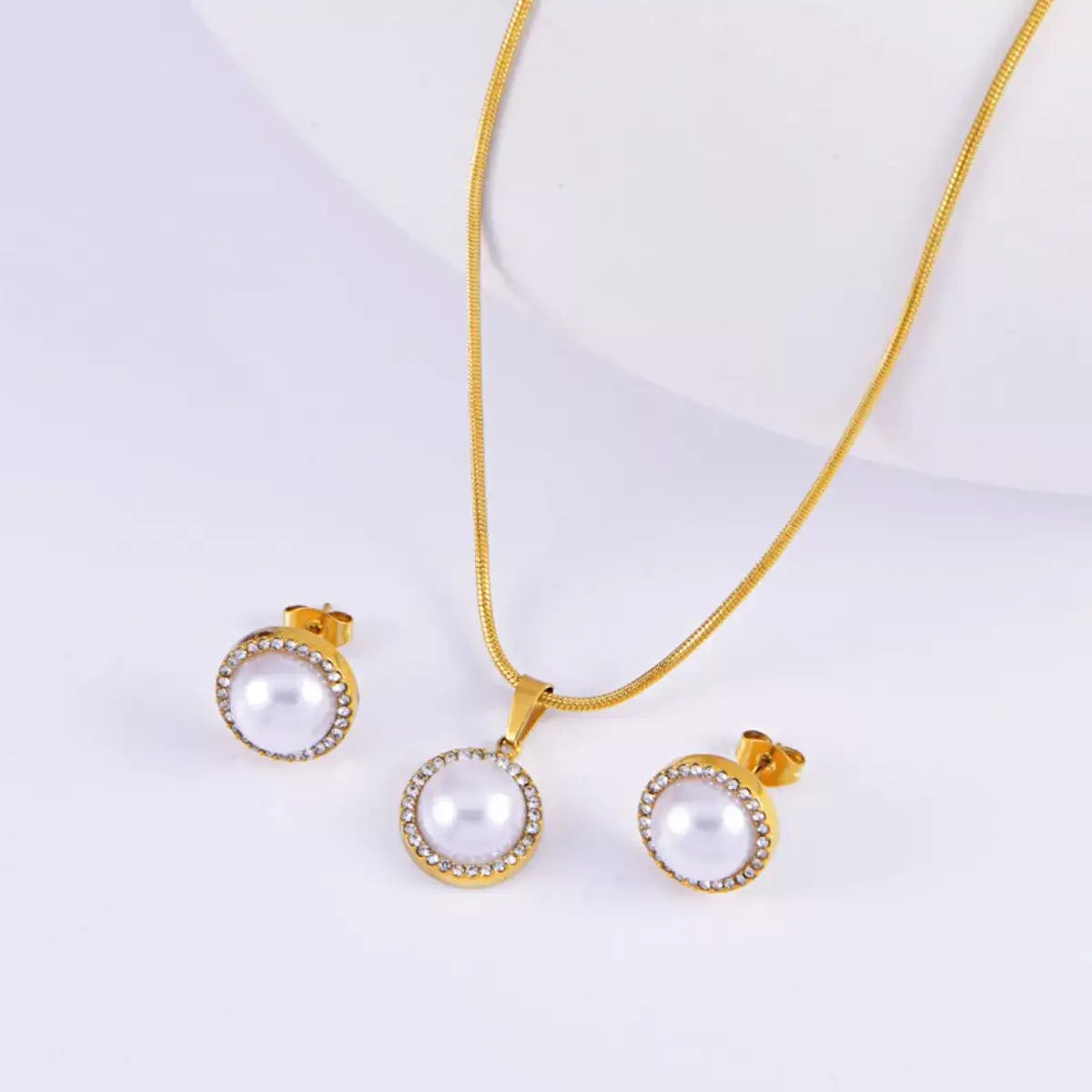 18K gold-plated Evie's Dreamland necklace and earrings set featuring white pearls and rhinestone halos.