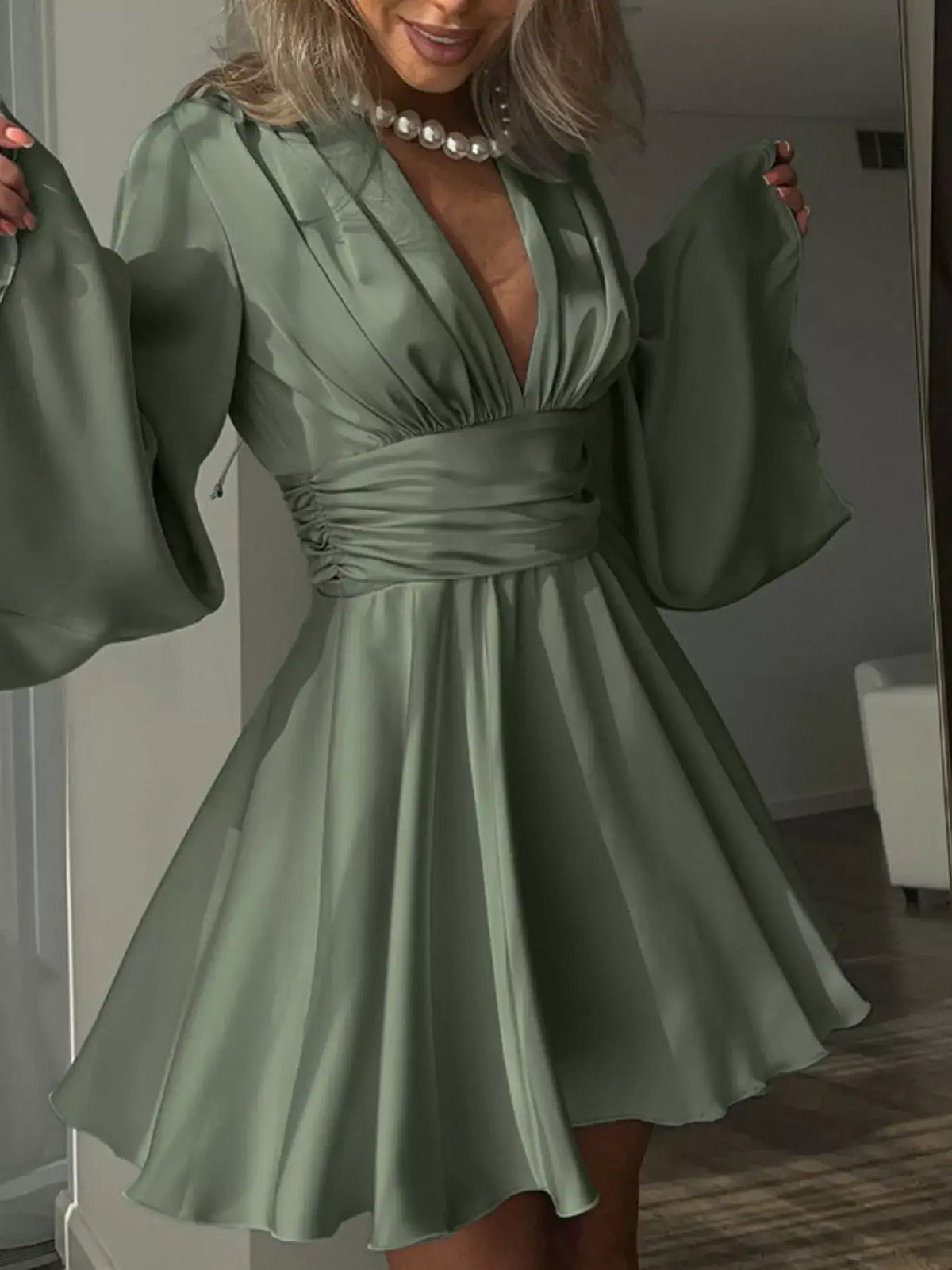 Sage green V-neck satin mini dress by Evie's Dreamland with flowy sleeves and a ruched waist.