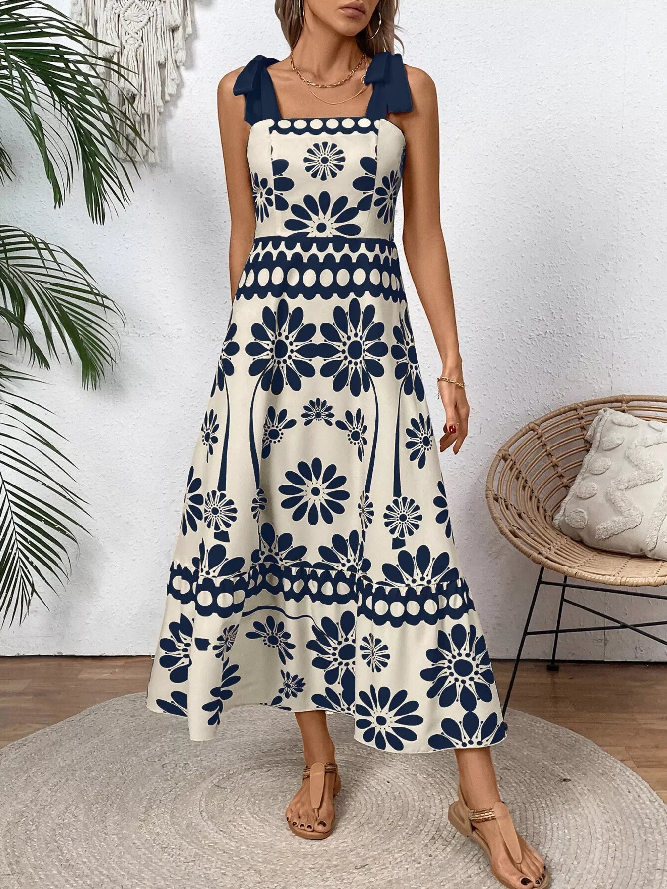 Blue floral tie-shoulder midi dress paired with a woven straw bag