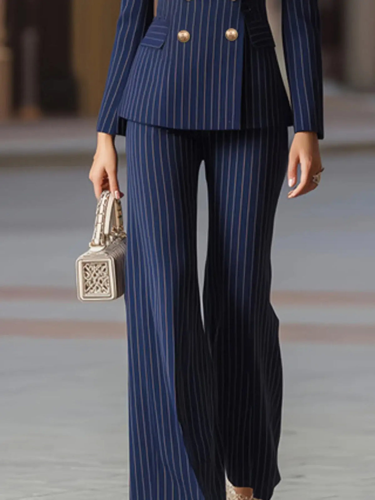 Evie's Dreamland navy blue pinstripe double-breasted blazer and wide leg pants set with a white handbag.