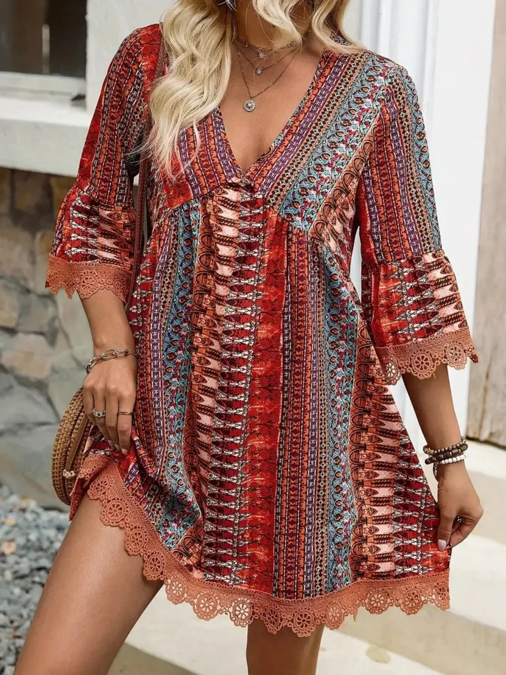 Boho chic women's mini dress with red, blue, and coral tribal print and lace trim sleeves and hem