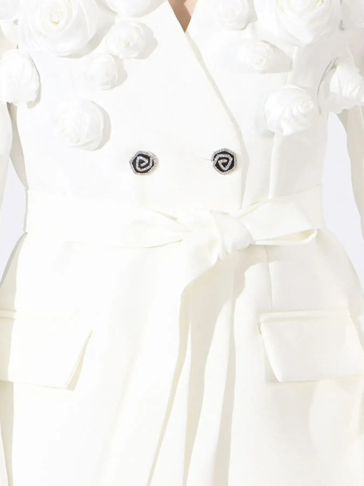White double-breasted blazer by Evie's Dreamland with 3D flower appliqués and a tie waist.
