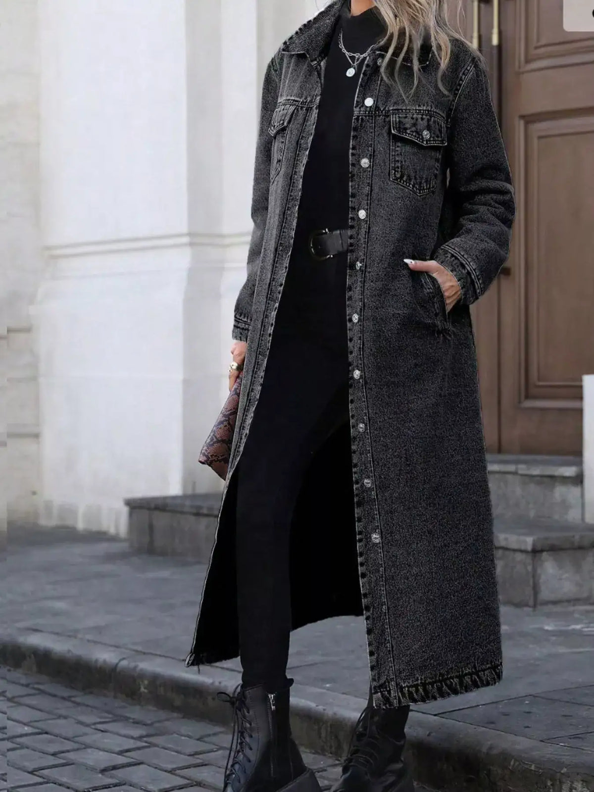 Woman wearing a longline charcoal grey denim jacket over a black turtleneck and skinny jeans.