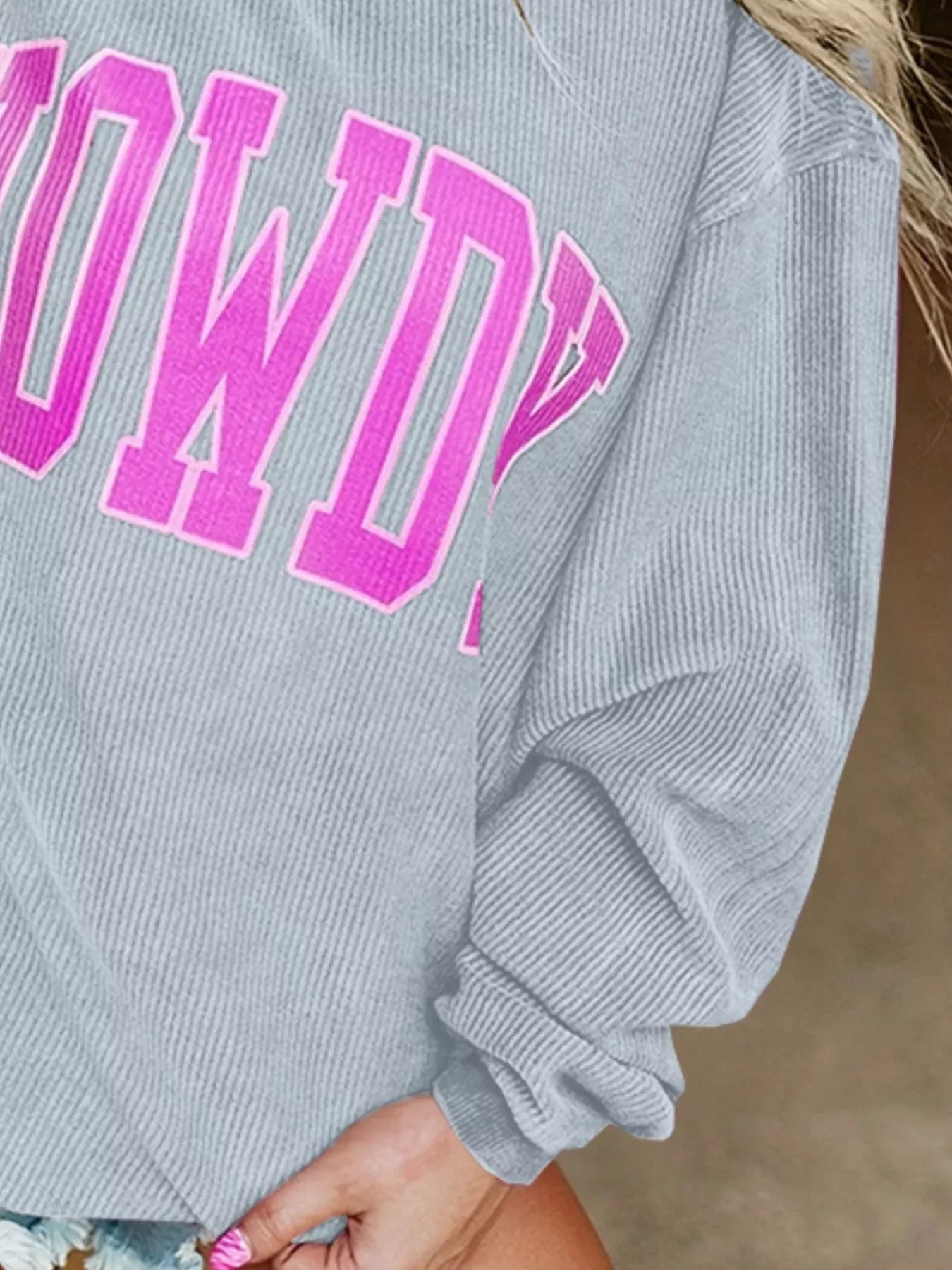Gray sweatshirt with pink bold text "COWDY" and ribbed fabric texture