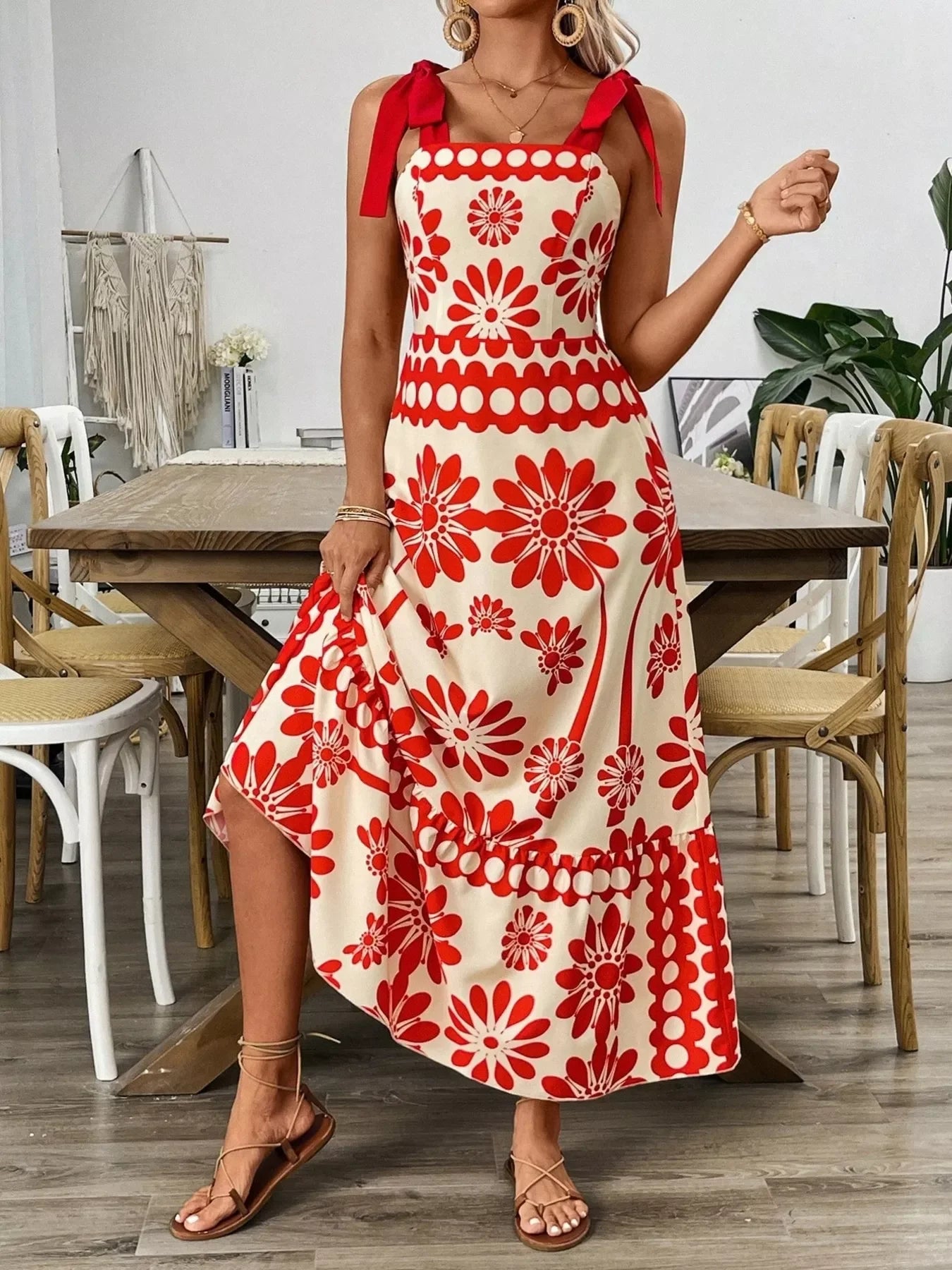 Red floral print midi dress with tie straps, styled with strappy sandals for a chic summer look.