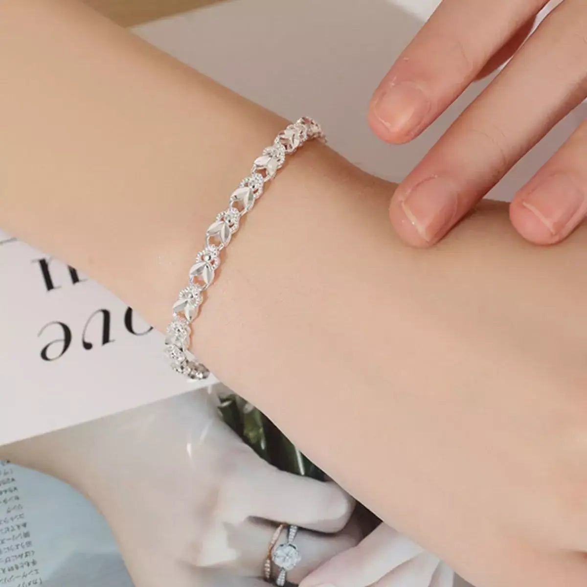 Evie's Dreamland 925 sterling silver chain bracelet with an intricate floral design on a woman's wrist.