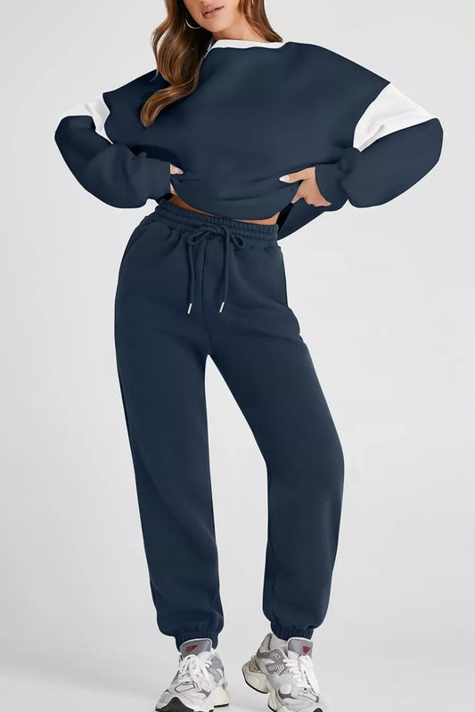 Woman wearing navy blue and white color block sweatshirt and matching jogger pants with white sneakers