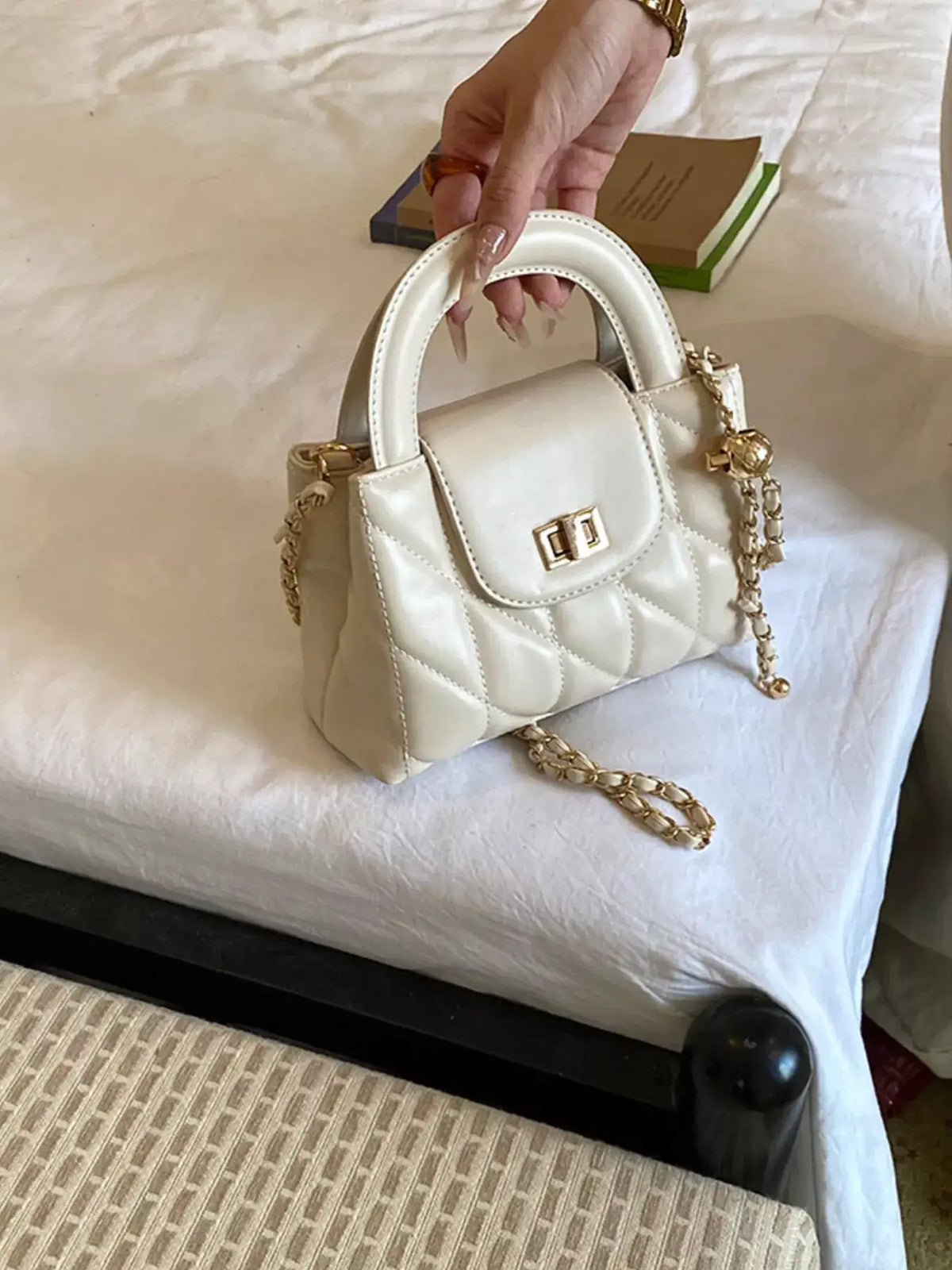 Evie's Dreamland cream quilted PU leather crossbody bag with gold chain strap and top handle.
