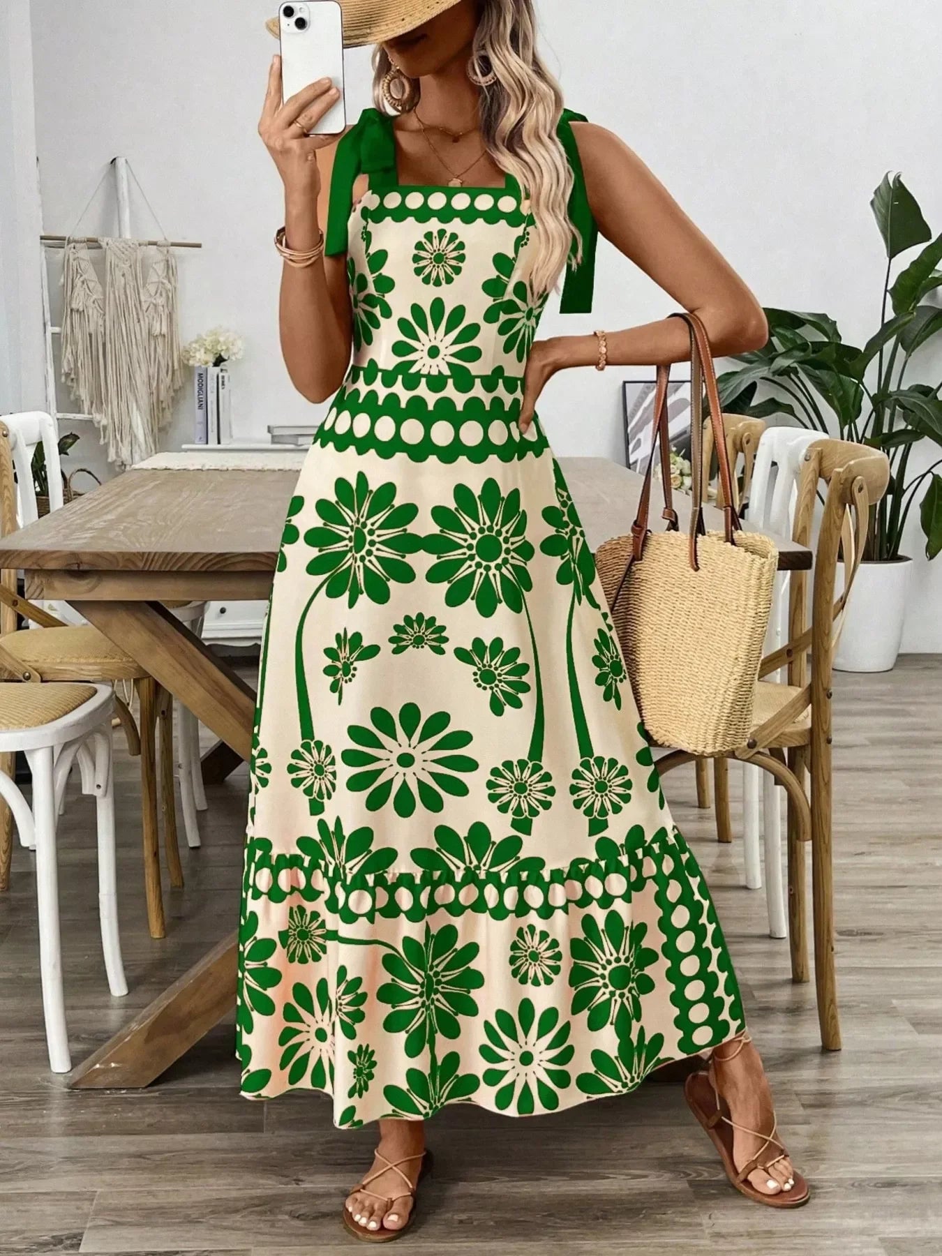 Green floral maxi dress with square neckline, paired with straw bag and sandals for summer elegance.