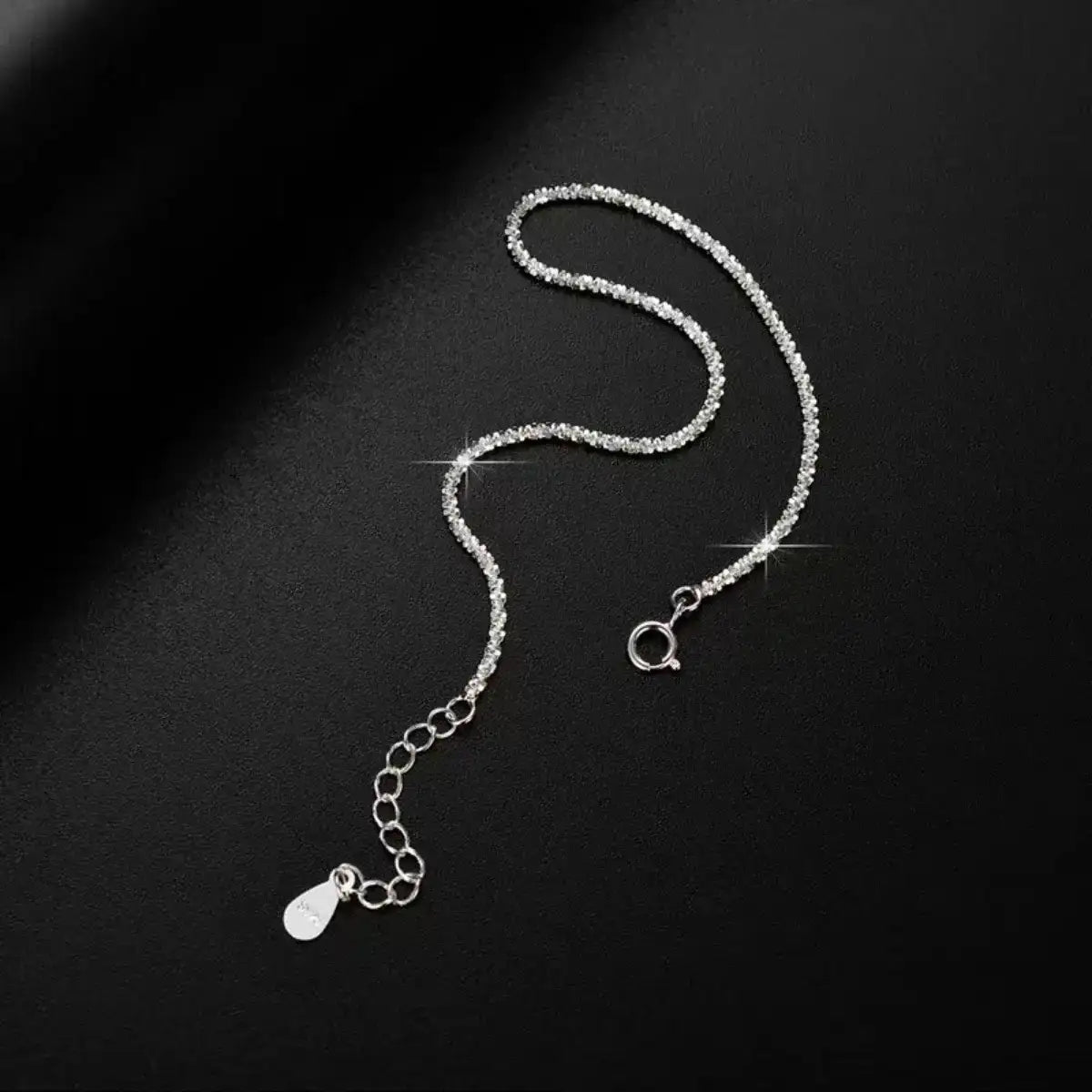 Evie's Dreamland 925 sterling silver adjustable chain bracelet with sparkling crystals on a black background.