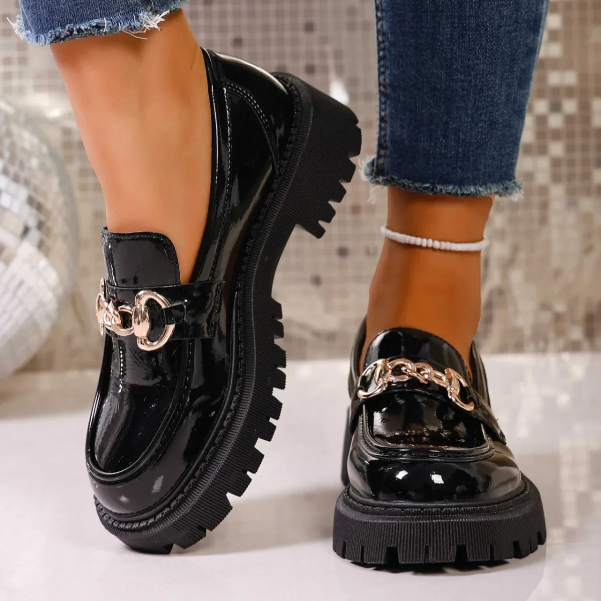 Black chain-detail slip-on loafers side profile showing mid heel and round toe