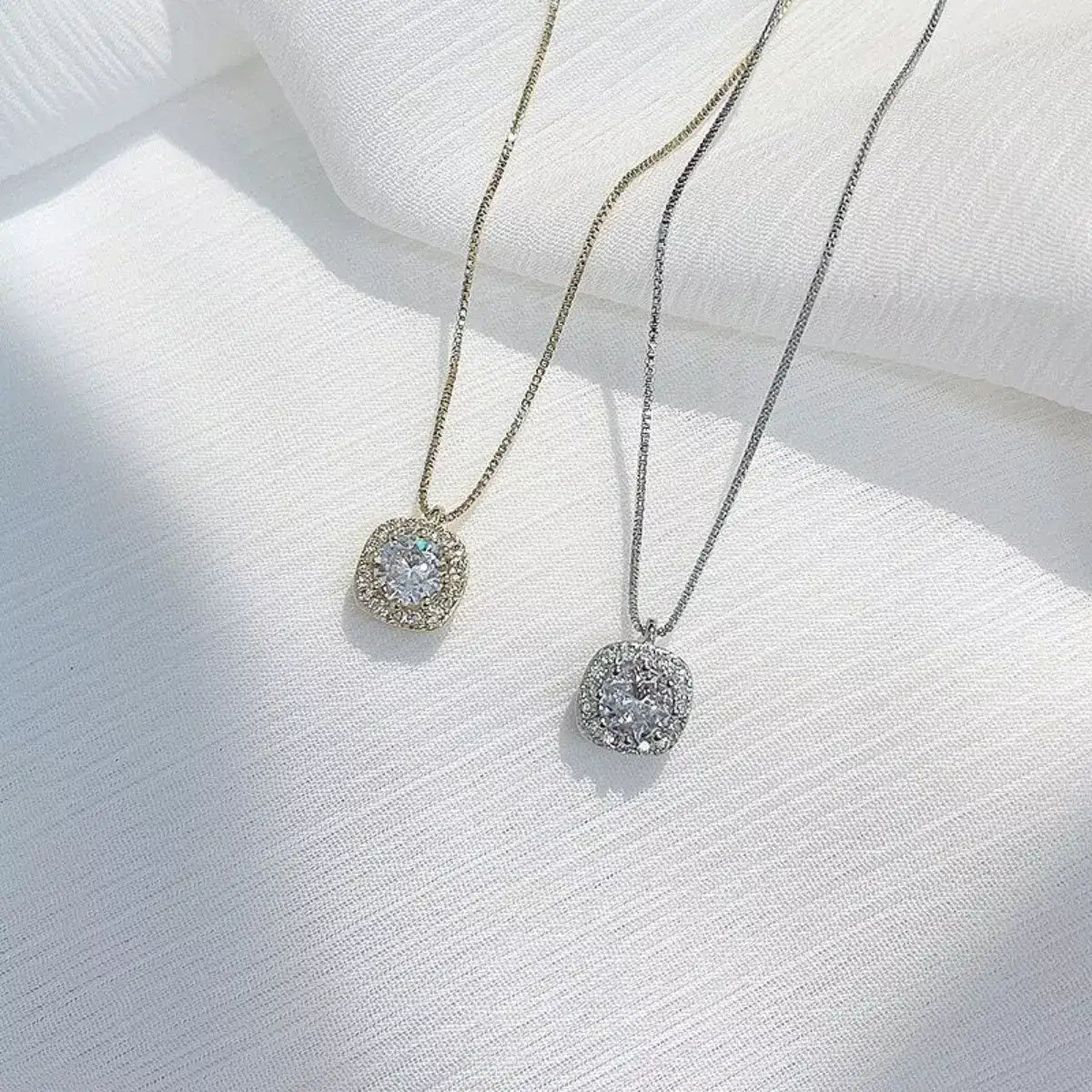 Gold and silver 925 Sterling Silver Zircon pendant necklaces by Evie's Dreamland on a white fabric.