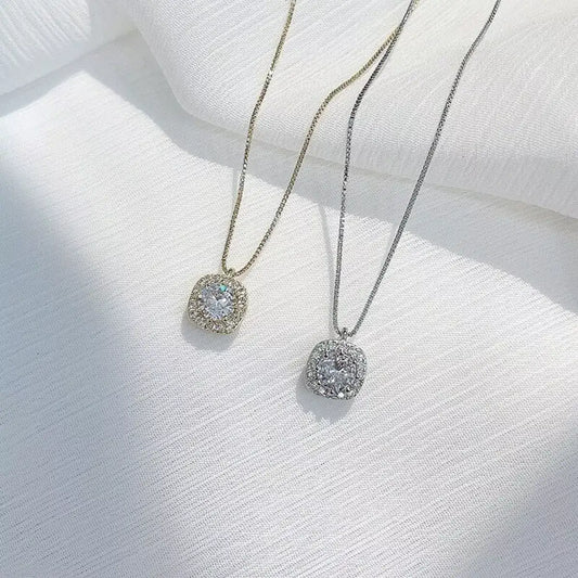 Gold and silver 925 Sterling Silver Zircon pendant necklaces by Evie's Dreamland on a white fabric.