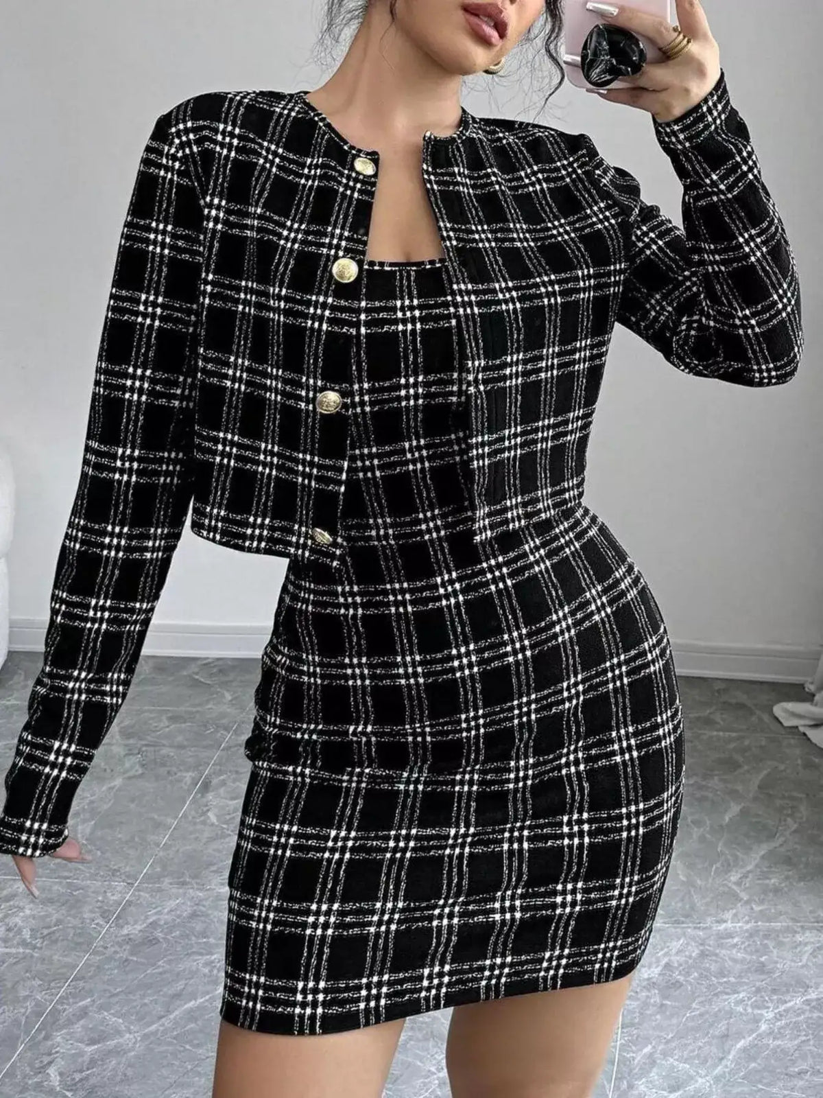 Woman wearing a plaid tweed crop jacket and matching bodycon mini dress set