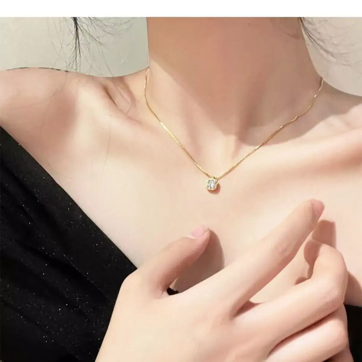 Woman wearing a gold Evie's Dreamland sterling silver zircon pendant necklace with a thin chain.