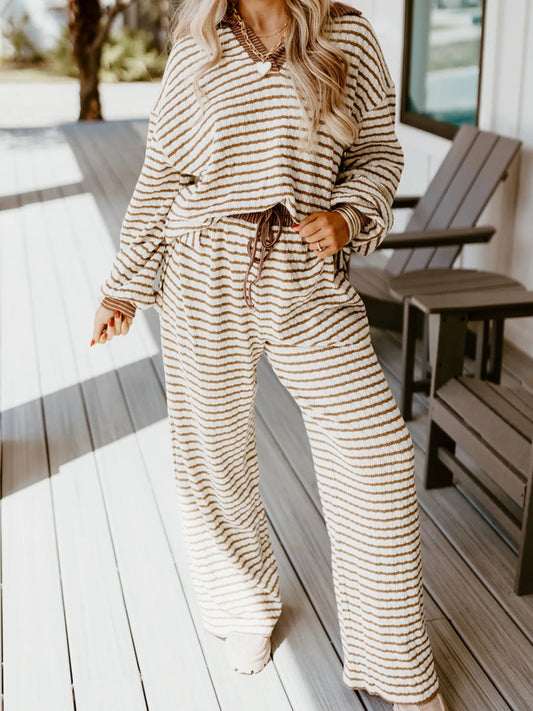 Woman wearing cozy beige and brown striped loungewear set with drawstring pants on wooden porch