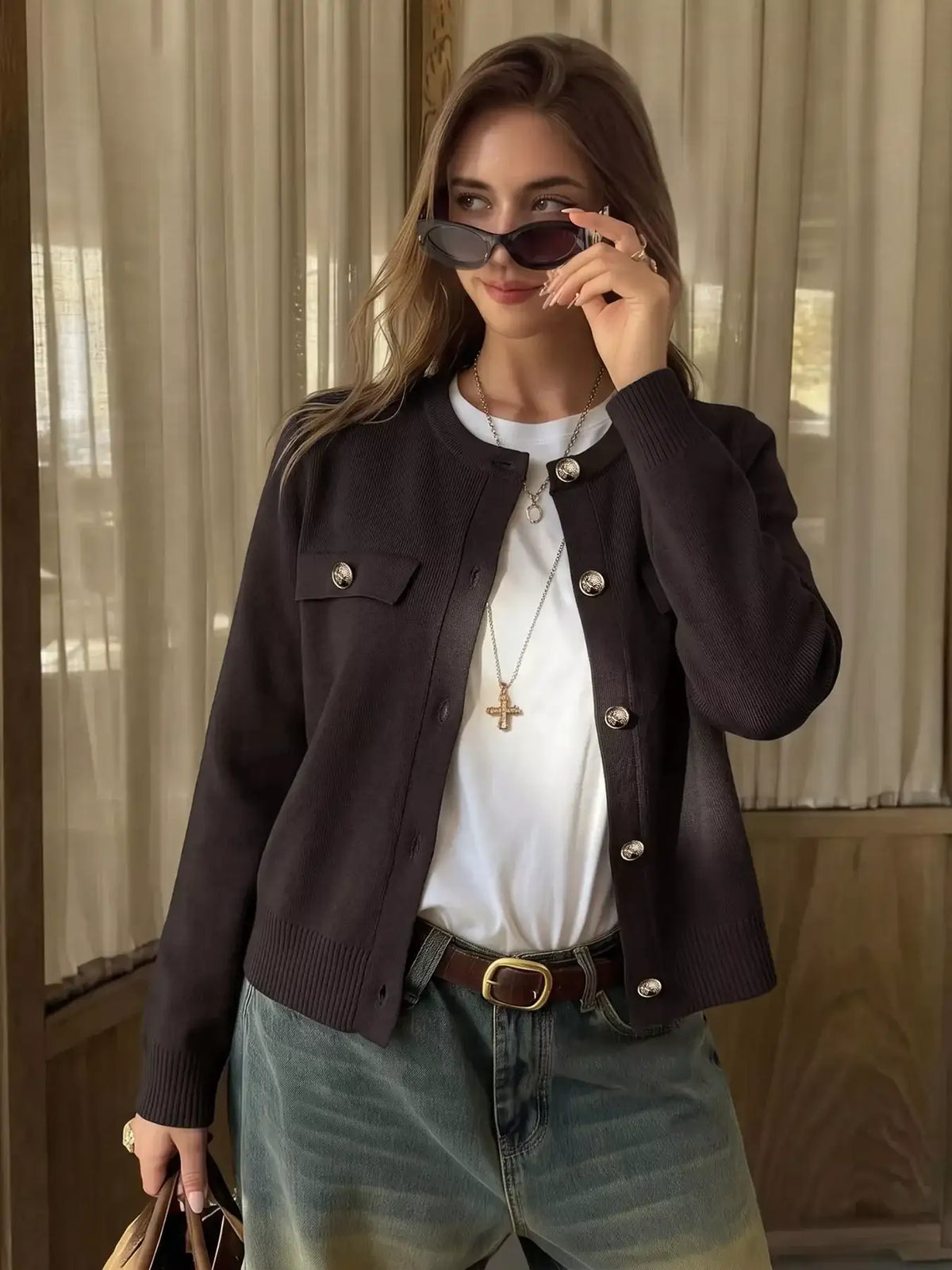 Woman wearing a dark brown button down knit cardigan over a white tee and blue jeans from Evie's Dreamland.