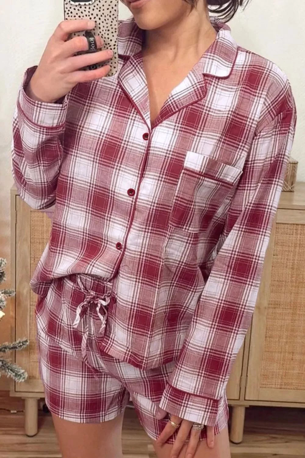 Woman wearing cozy red and white plaid pajama set with button-up top and shorts