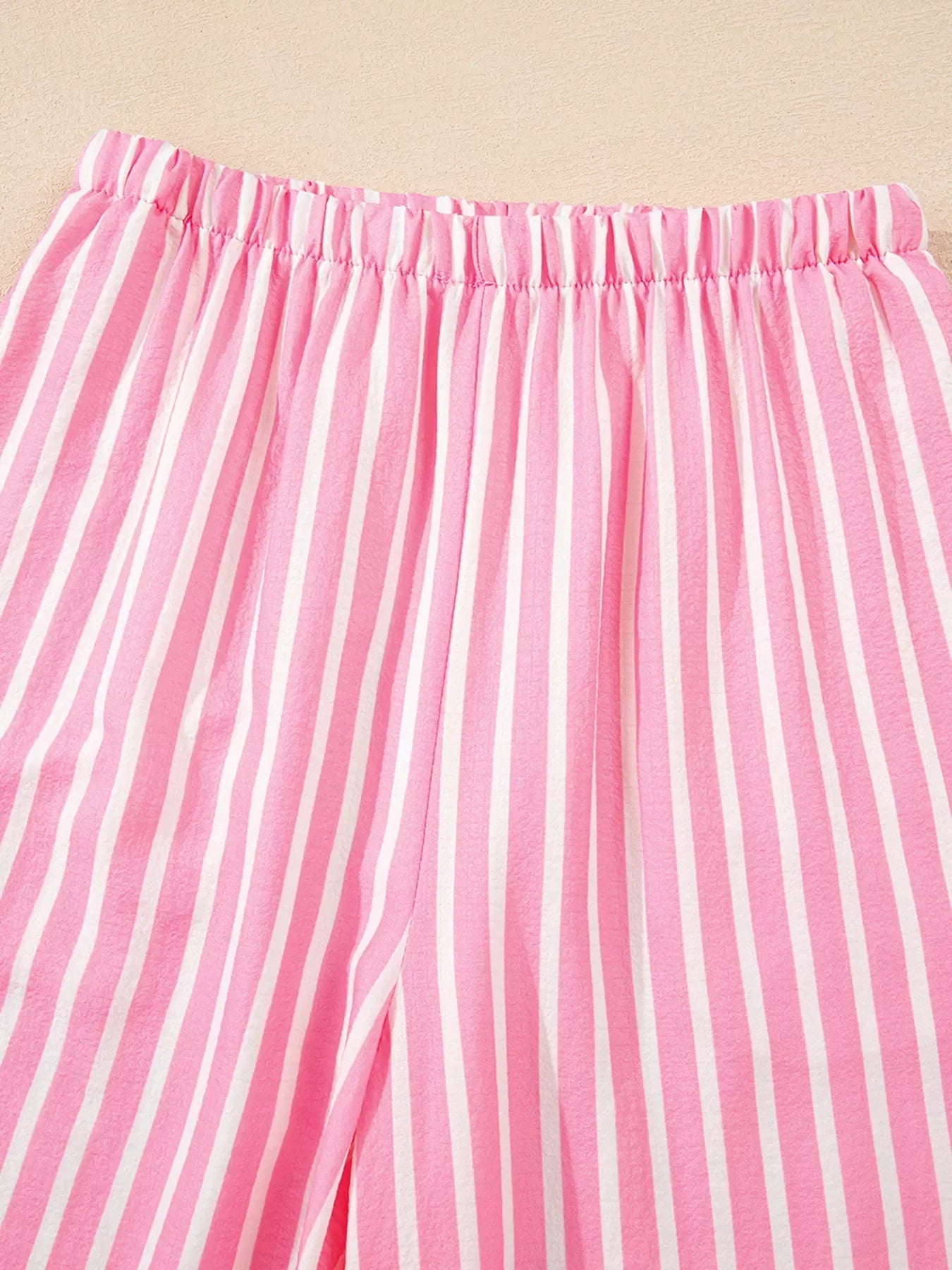 Pink and white vertical striped fabric with elastic waistband close-up