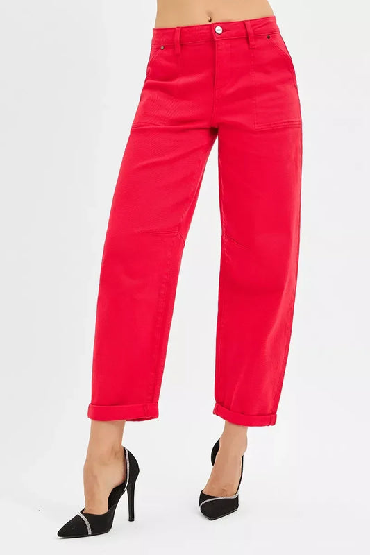 Woman wearing bright red high-waisted pants with cuffed hems and black high heels with rhinestone detail