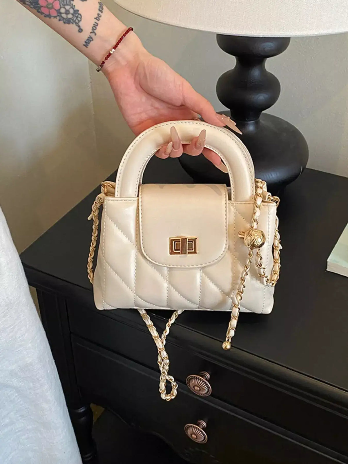 Cream quilted PU leather crossbody bag by Evie's Dreamland with gold chain strap and top handle.