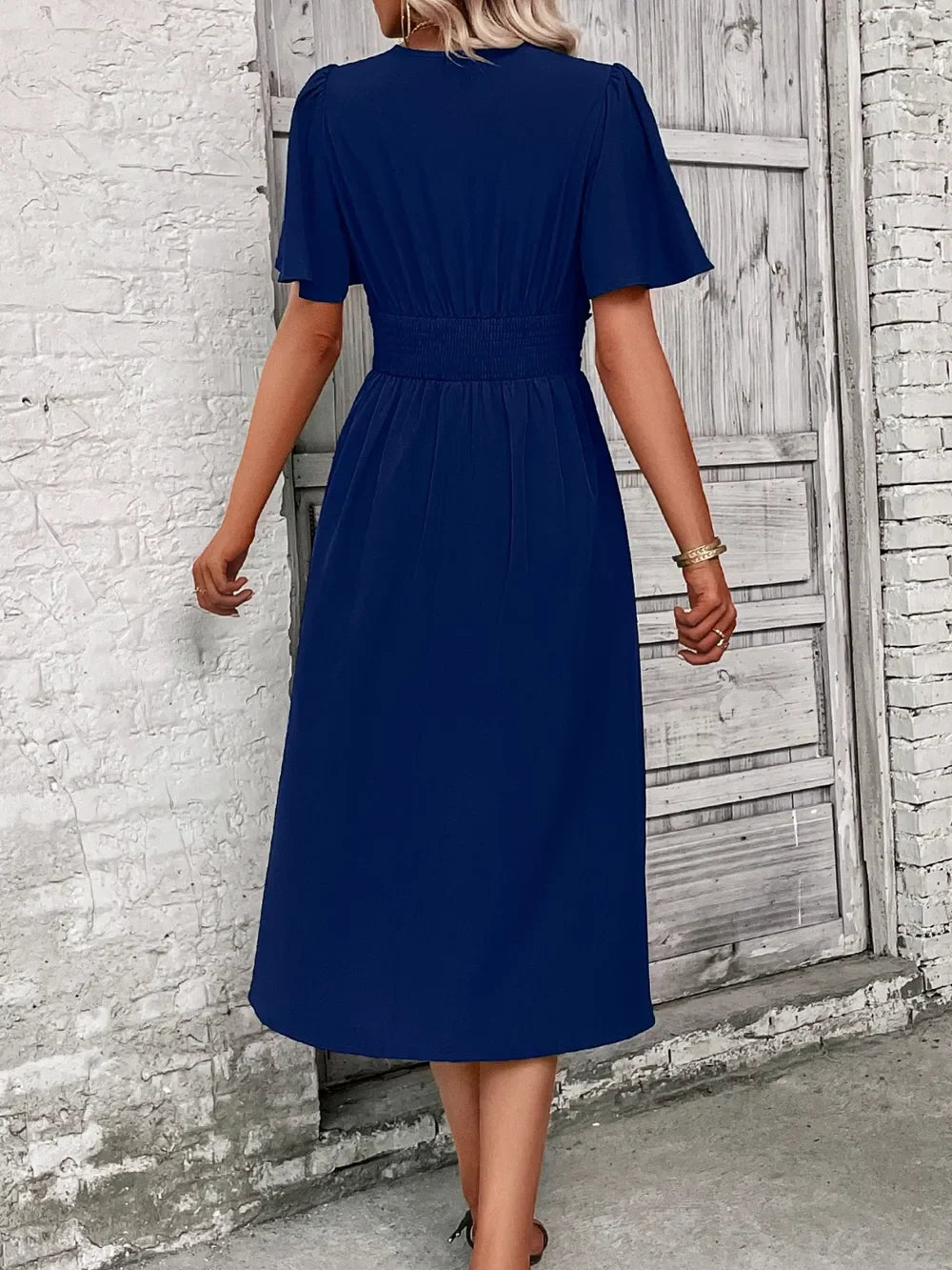 Navy blue midi dress with puff sleeves and elastic waist, styled for everyday elegance
